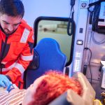 Zum Tag des Notrufs 112: Ein Rettungssanitäter der Johanniter versorgt eine Patientin im Rettungswagen.