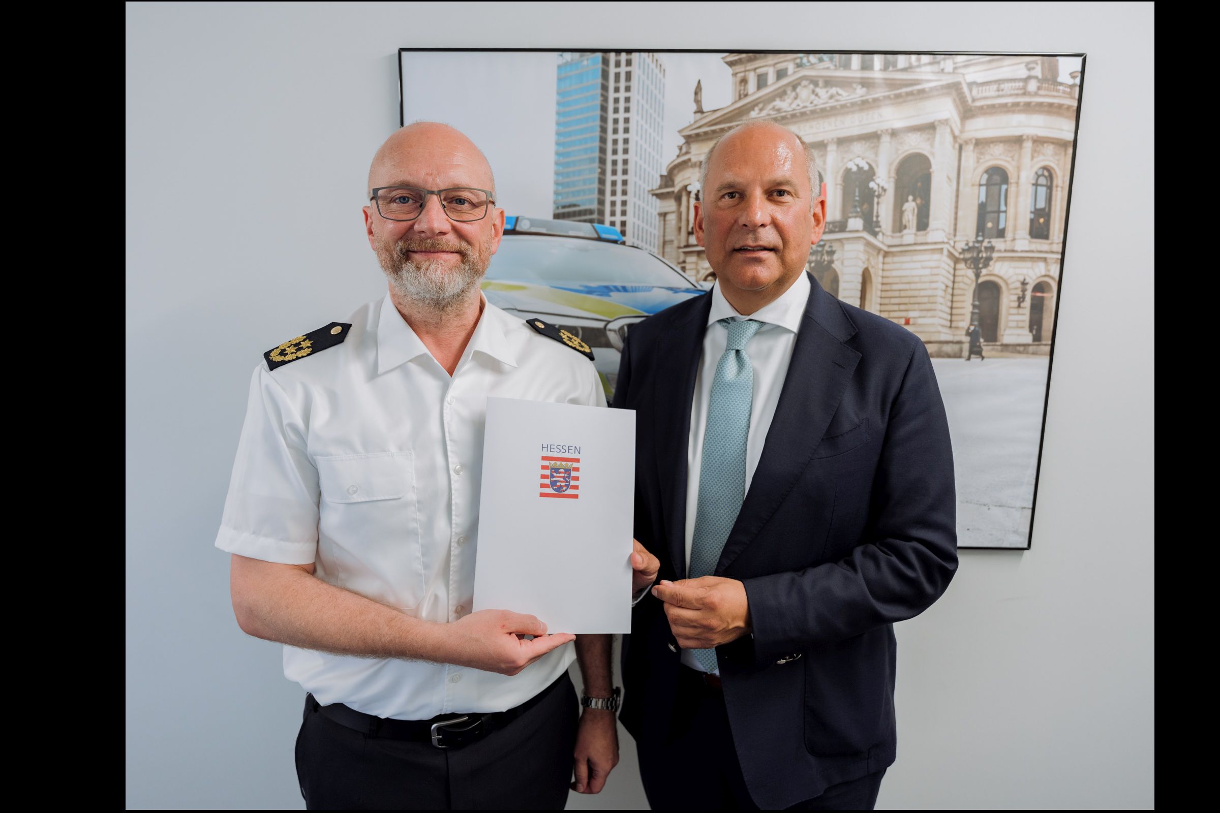 Innenminister Roman Poseck überreicht dem designierten Polizeipräsidenten von Südhessen, Christian Vögele, seine Ernennungsurkunde.