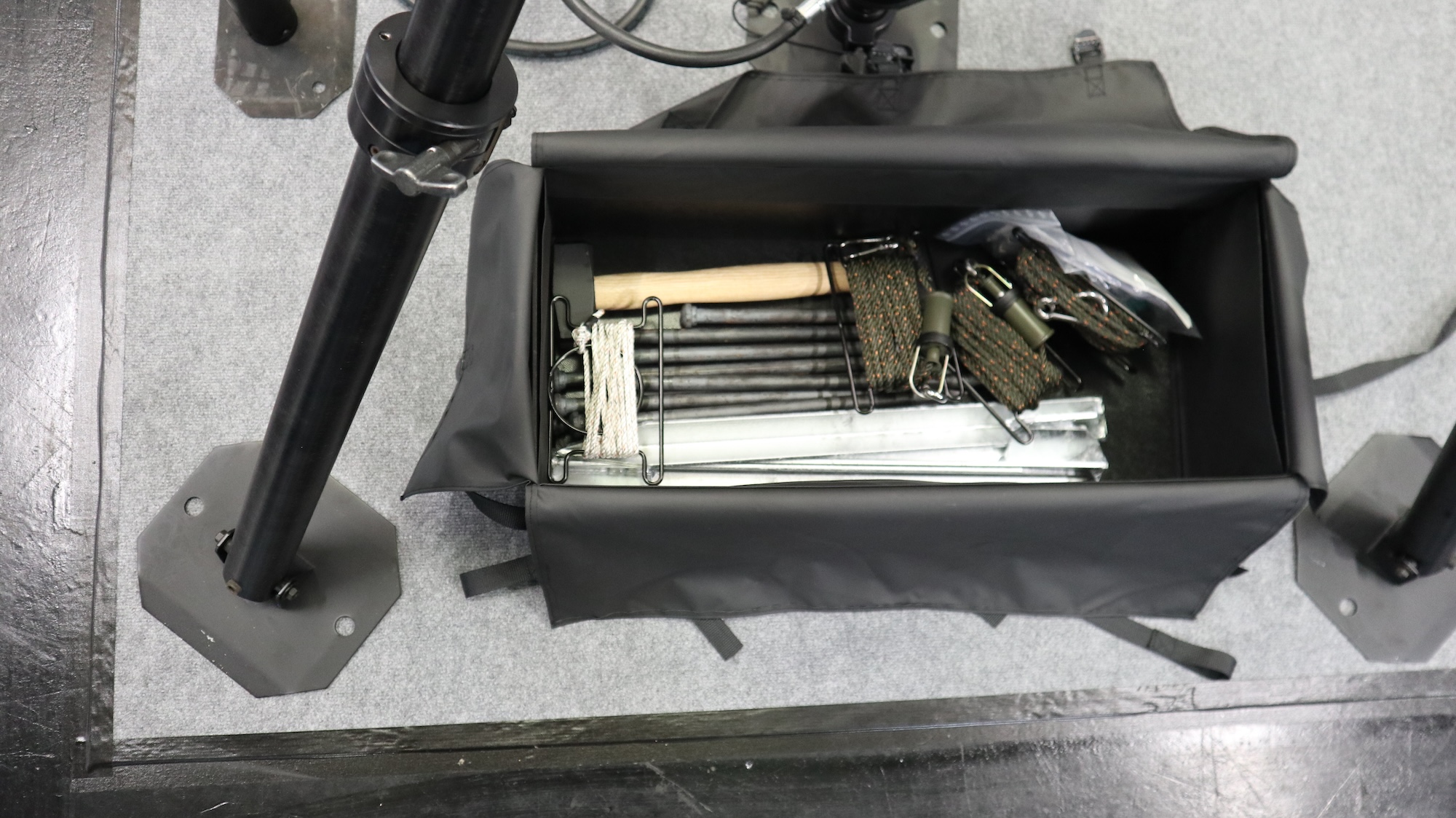 Zwei Taschen für je zwei Stützfüße, eine Tasche für den Mast und eine Tasche für das Zubehör (hier im Bild) benötigt der neue Mast. Gut zu sehen: Pro Fuß werden zwei Erdnägel eingeschlagen.