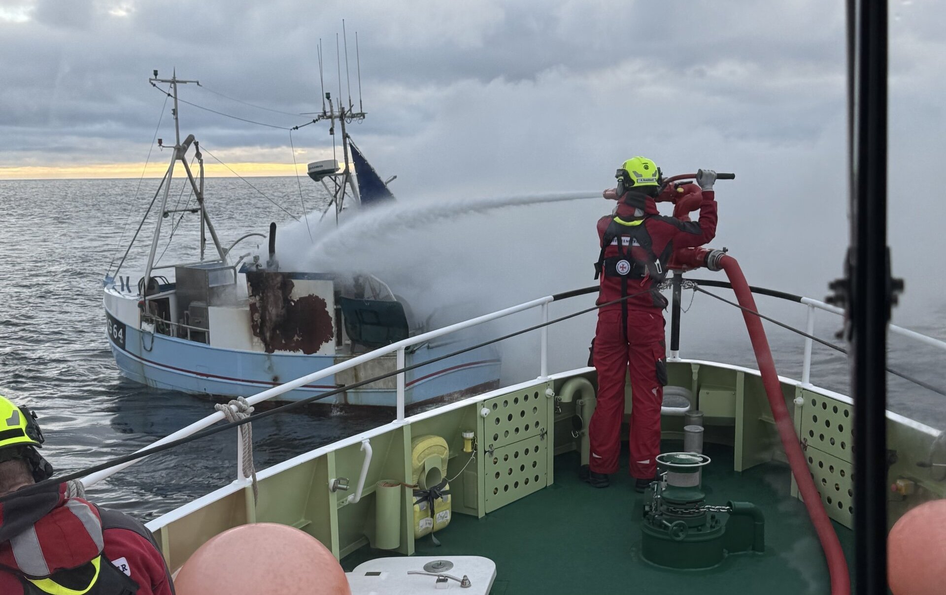 Mit dem leistungsstarken Feuerlöschmonitor des Seenotrettungskreuzers FRITZ KNACK löscht die Besatzung den Brand auf dem havarierten Fischkutter.