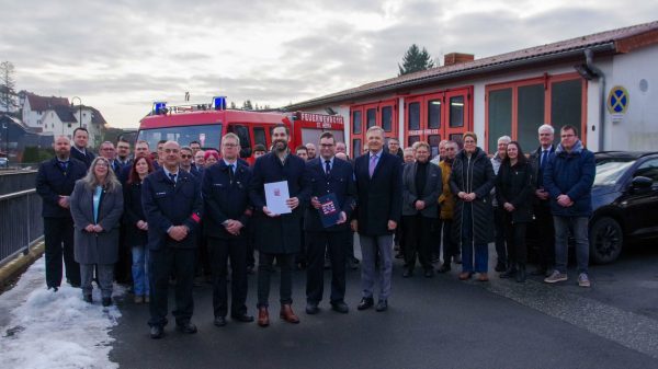 Neue Feuerwehrhäuser und Fahrzeuge für Hessens Feuerwehren: von links nach rechts: Gruppenfoto - 1. Reihe: Herzberg, Stefan Wetterau (stellv. Wehrführer), Iliev, Erbe, Rößler vor dem aktuellen/alten Gerätehaus