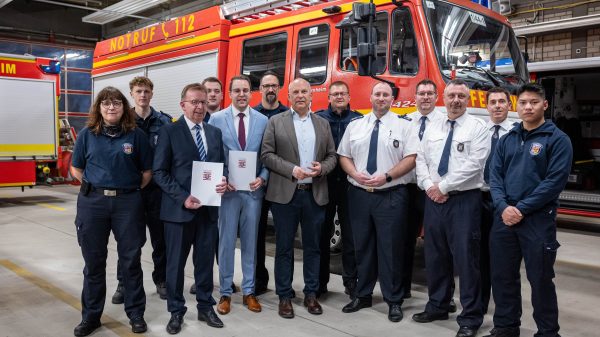 Innenminister Roman Poseck bei der Bescheidübergabe zusammen mit dem Ersten Stadtradt Jörg Schneidel, Bürgermeister Matthias Baaß und Feuerwehrleuten der Feuerwehr Viernheim
