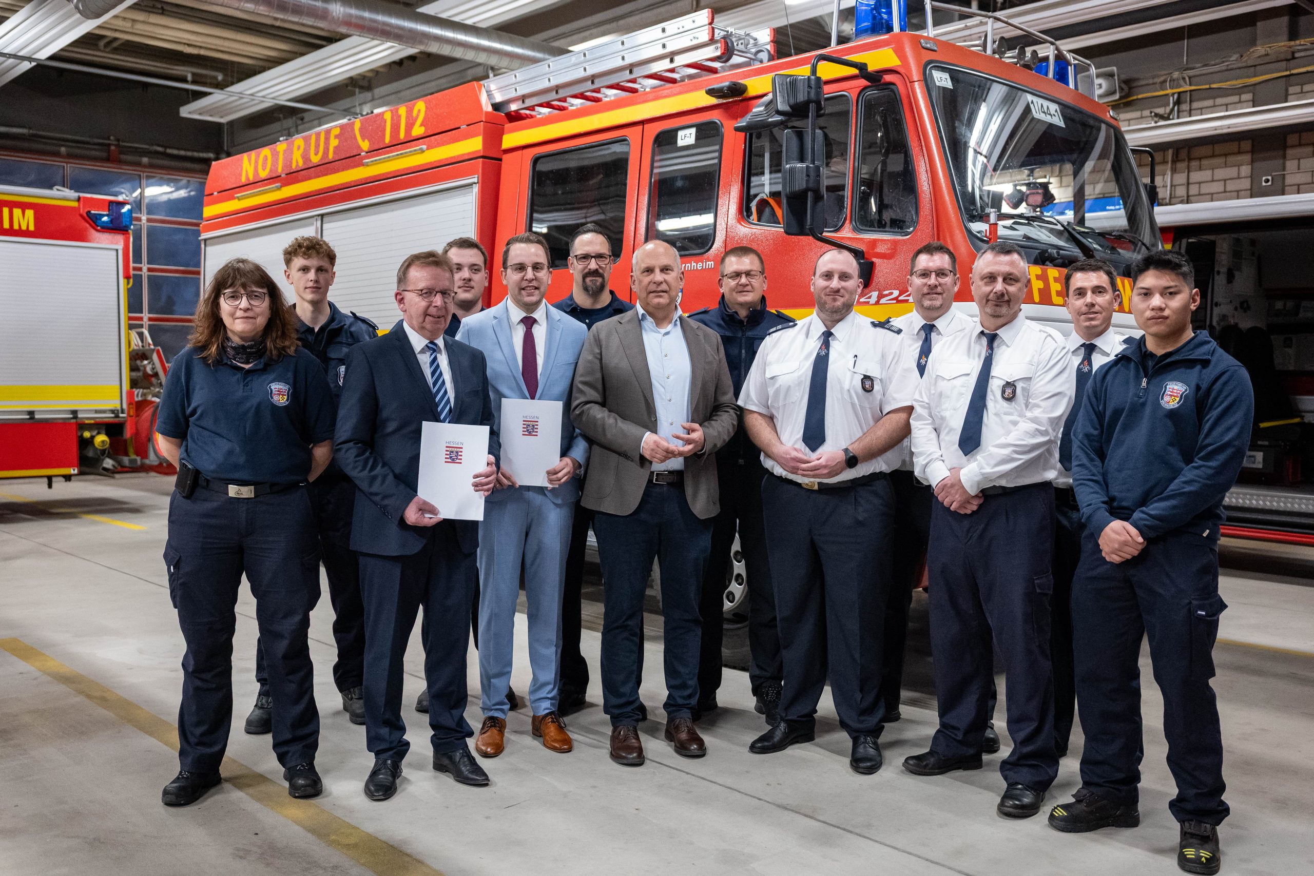 Innenminister Roman Poseck bei der Bescheidübergabe zusammen mit dem Ersten Stadtradt Jörg Schneidel, Bürgermeister Matthias Baaß und Feuerwehrleuten der Feuerwehr Viernheim